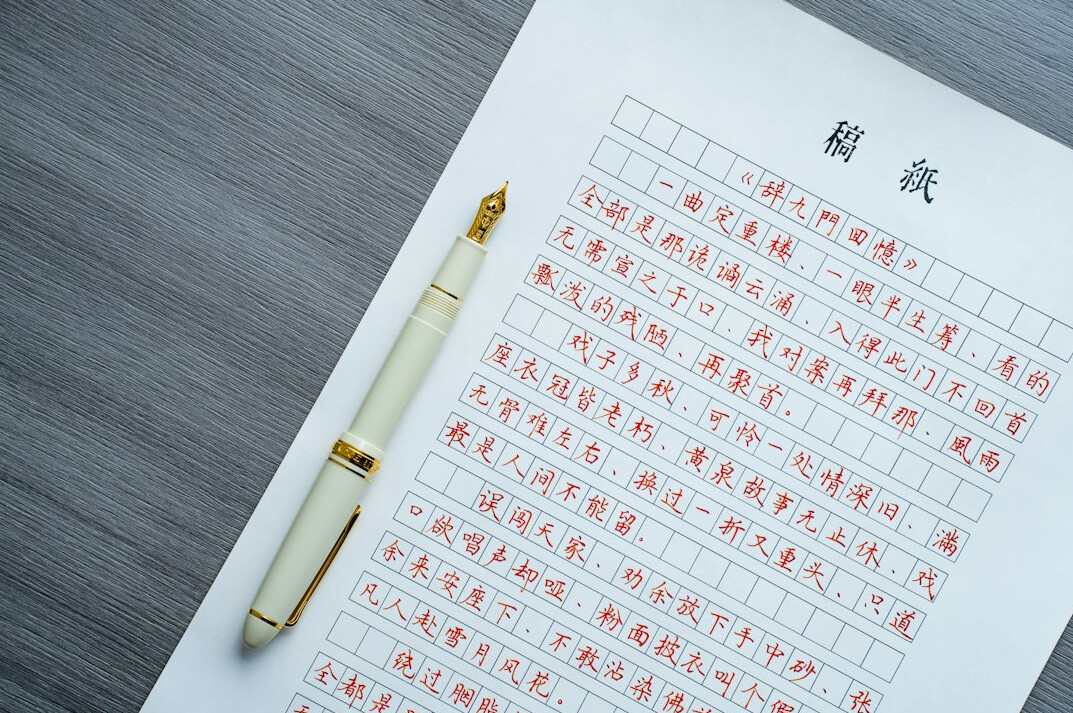 Overlapping documents with a red confidential stamp and a pen